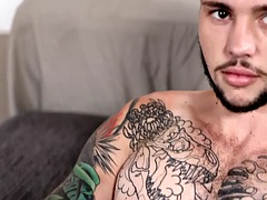 Tattooed stud stroking his hairy shaft during a solo scene