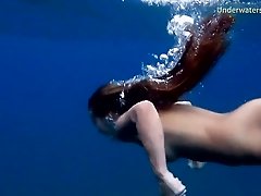 Seductive dame dives into the ocean with her perky tits out