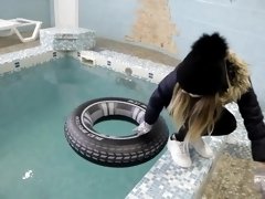 wetlook girl with winter clothes swims in the pool